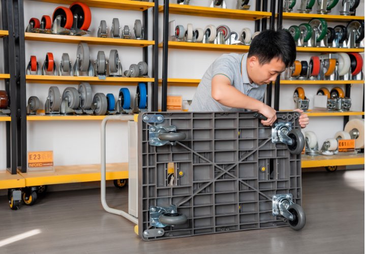 Workers install the industrial casters on the cart